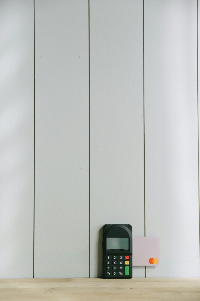 A sleek payment terminal with buttons against a white wooden background, ideal for finance concept.